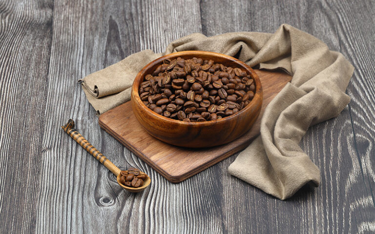 Ground coffee and coffee beans in the wood bowls